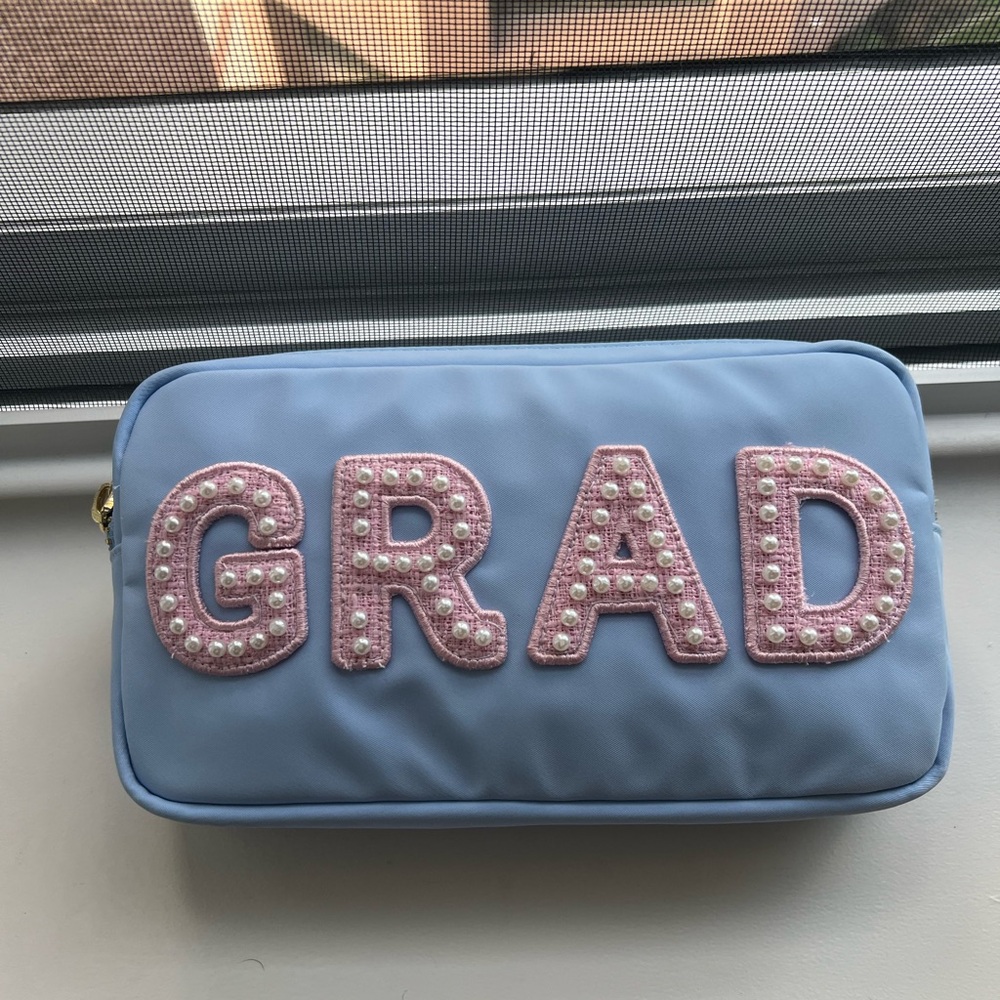 Periwinkle Stoney Clover pouch with “GRAD” patched on. NWT never used
